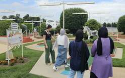 Four students with IRC staff playing mini golf.